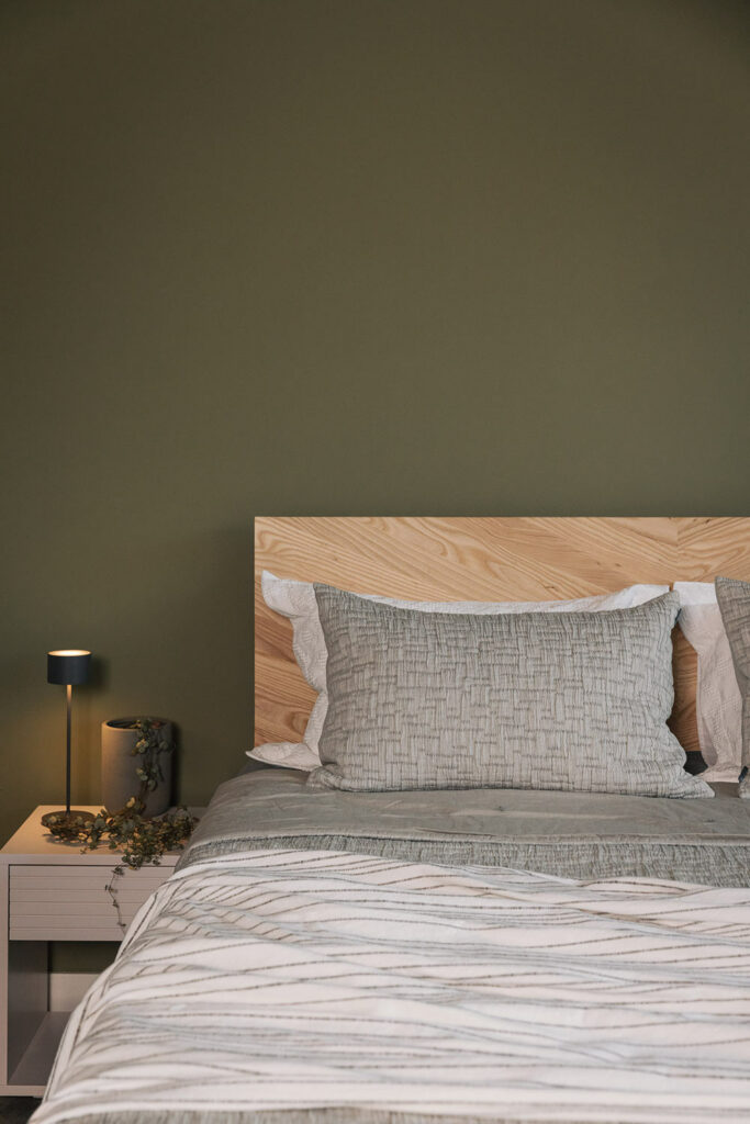 A superking solid Ash Hathersage bed with chevron pattern headboard shown with moss grey bedding