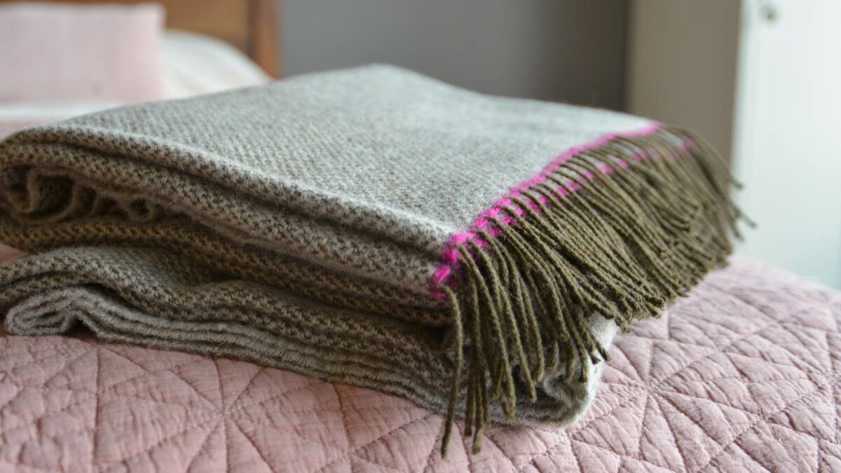 grey wool throw with pink edge and brown fringe