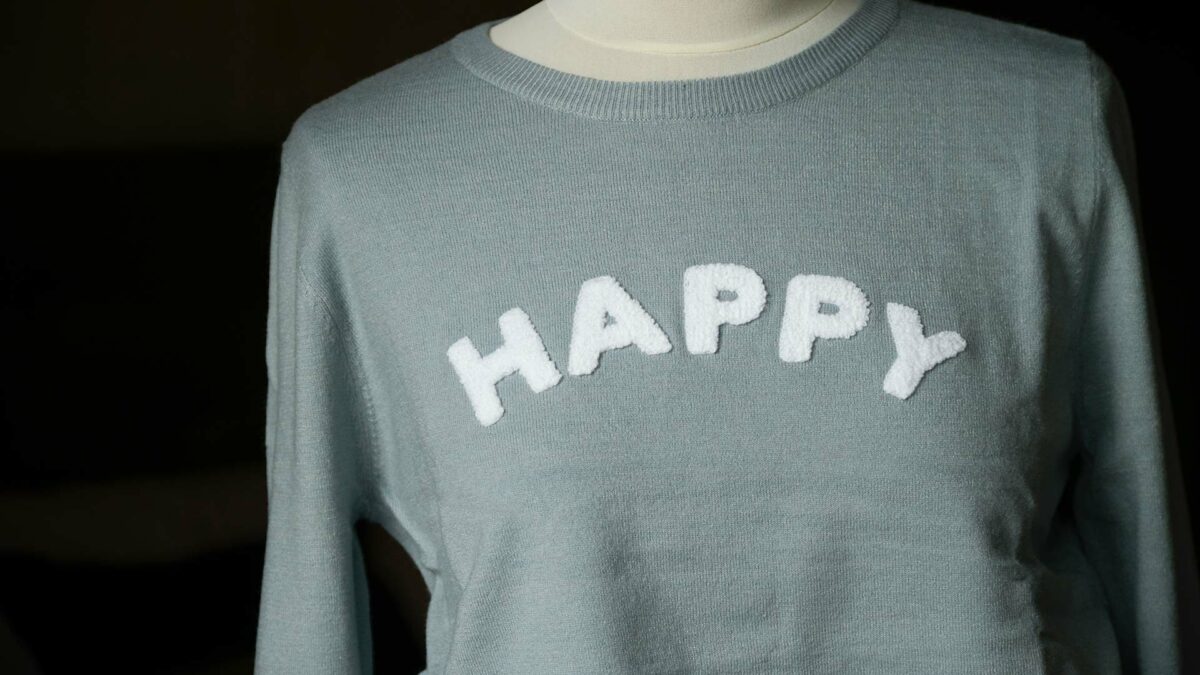 happy motif on pale blue jumper