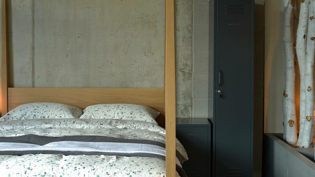 Hatfield Tall Post Bed in Oak shown with Terrazzo print bedding and lockers