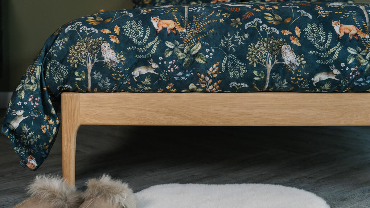 Dark green bedding with a nature print of foxes, plants, and owls