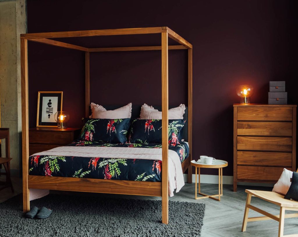 Printed floral bedding on the Walnut Highland wooden 4 poster bed shown with matching walnut drawers