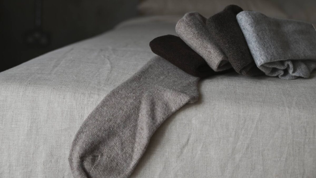 Dark brown, oatmeal, mid brown and grey socks folded.
