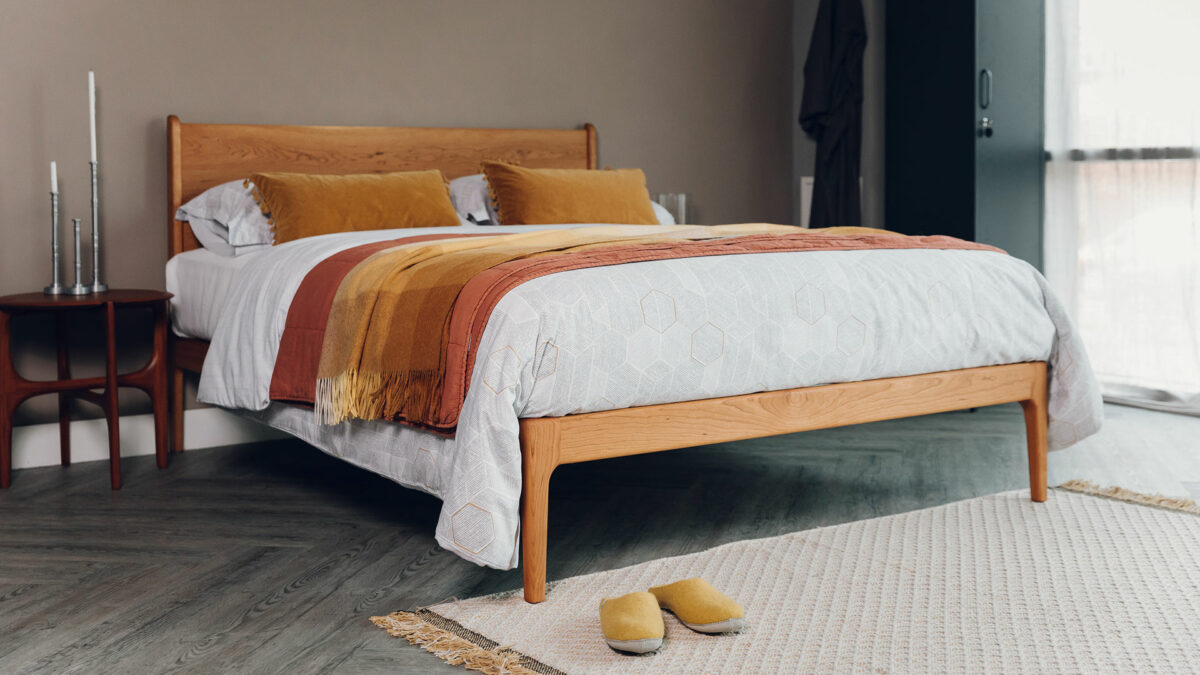 mid century style Camden bed in cherry with an oiled finish and shown with mustard and terracotta coloured bedding