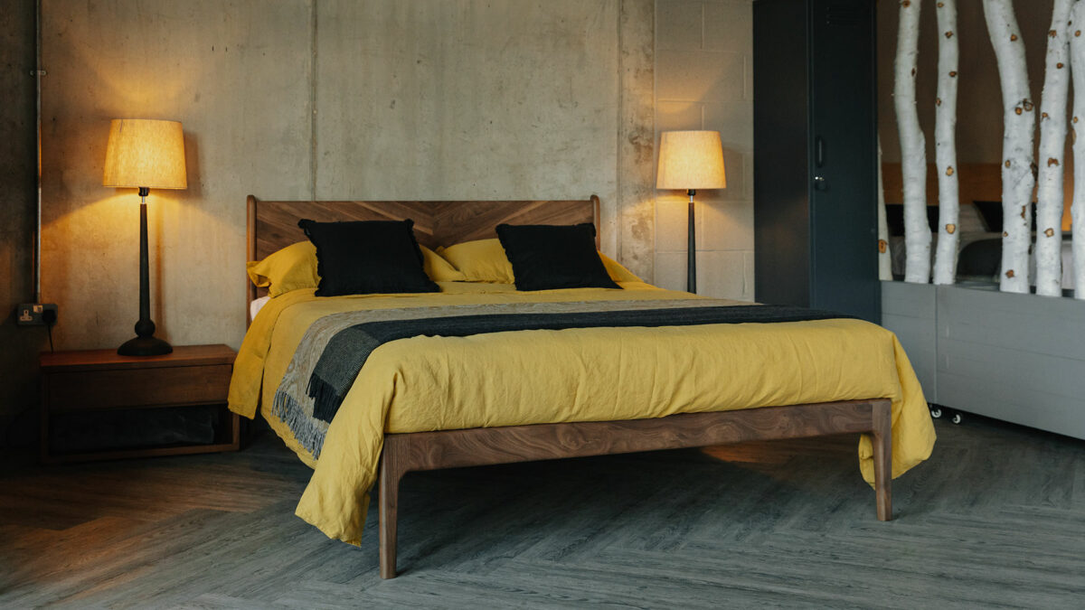 The Hoxton in walnut wood, a mid-century look bed with chevron pattern headboard, with two wooden lamp bases