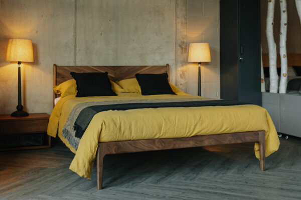 The Hoxton in walnut wood, a mid-century look bed with chevron pattern headboard, with two wooden lamp bases