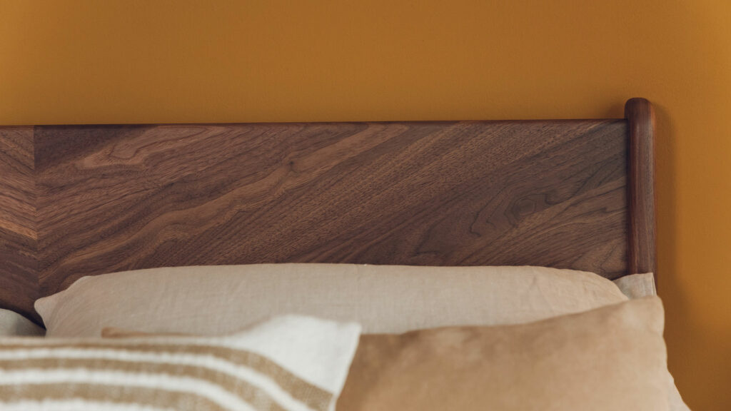 The Hoxton bed has a chevron pattern solid wood headboard here shown in walnut