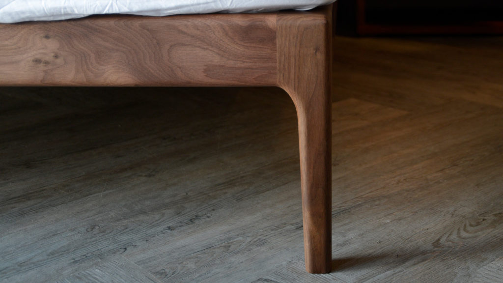 A closer view of the tapered leg of our solid walnut Hoxton bed