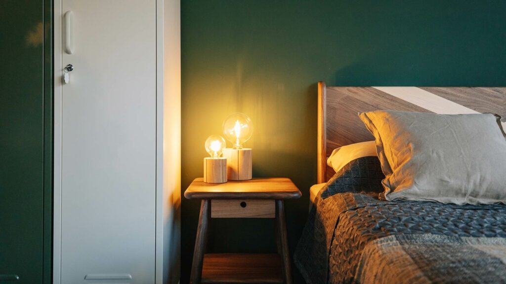 mid century look bedside table with a pair of wooden lamps