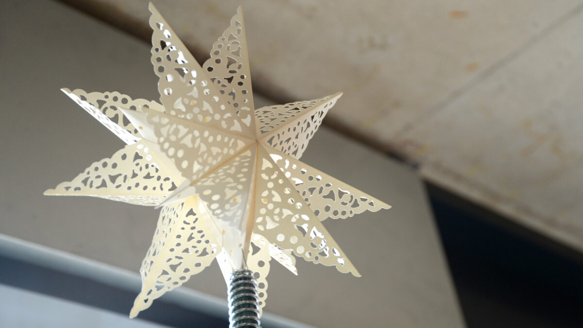 paper star Xmas decoration to top a xmas tree with cut-out lace patterns