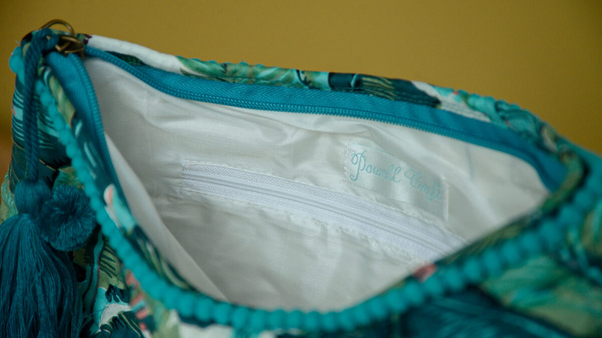 Close up of silky inside lining of toiletry bag showing a zipped off section.