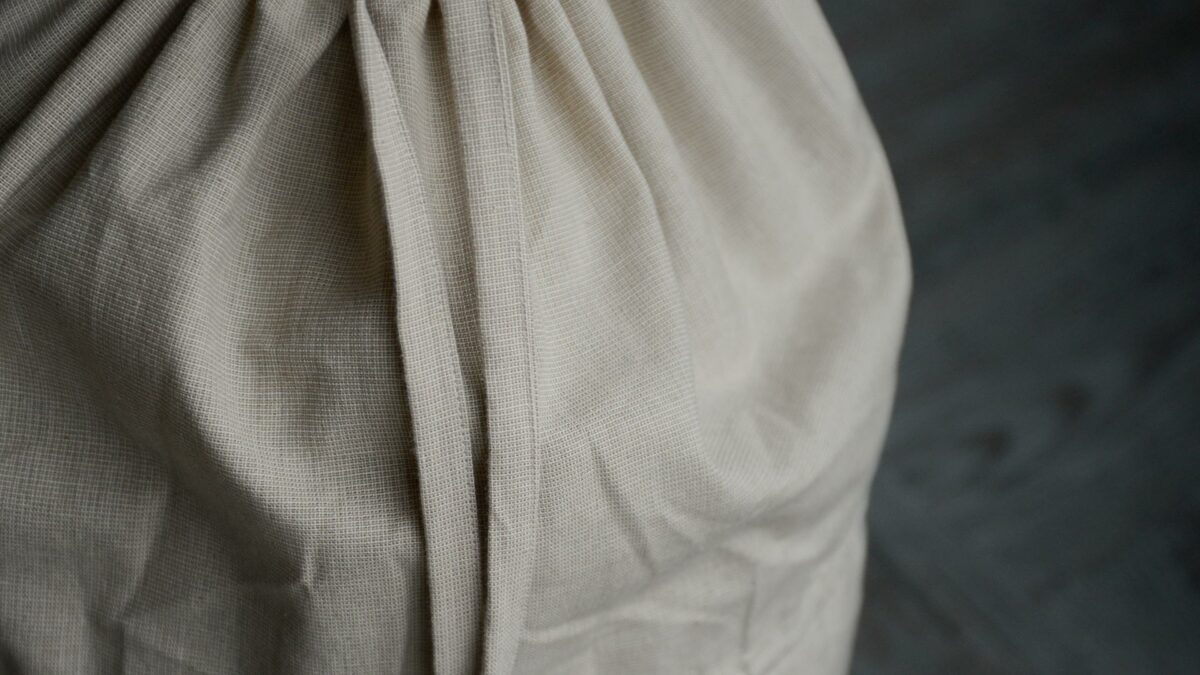 pale beige draw string laundry bag shown close up