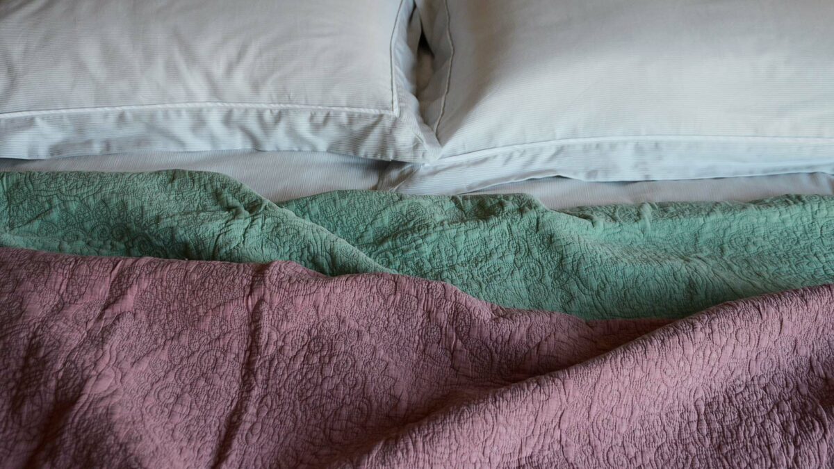 floral embroidered quilted bedspreads in sage green and dusky pink