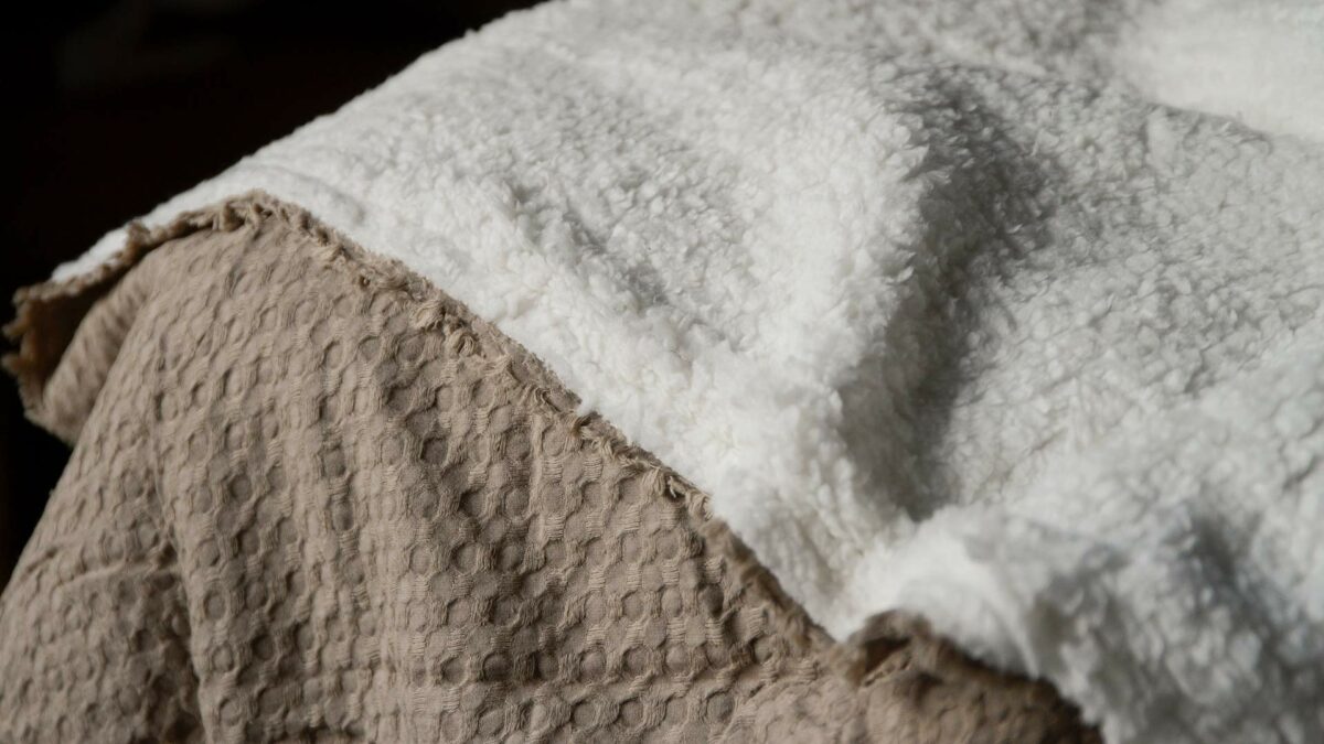 light brown blanket with white fleece reverse