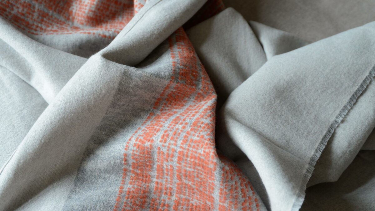 light grey and warm red throw