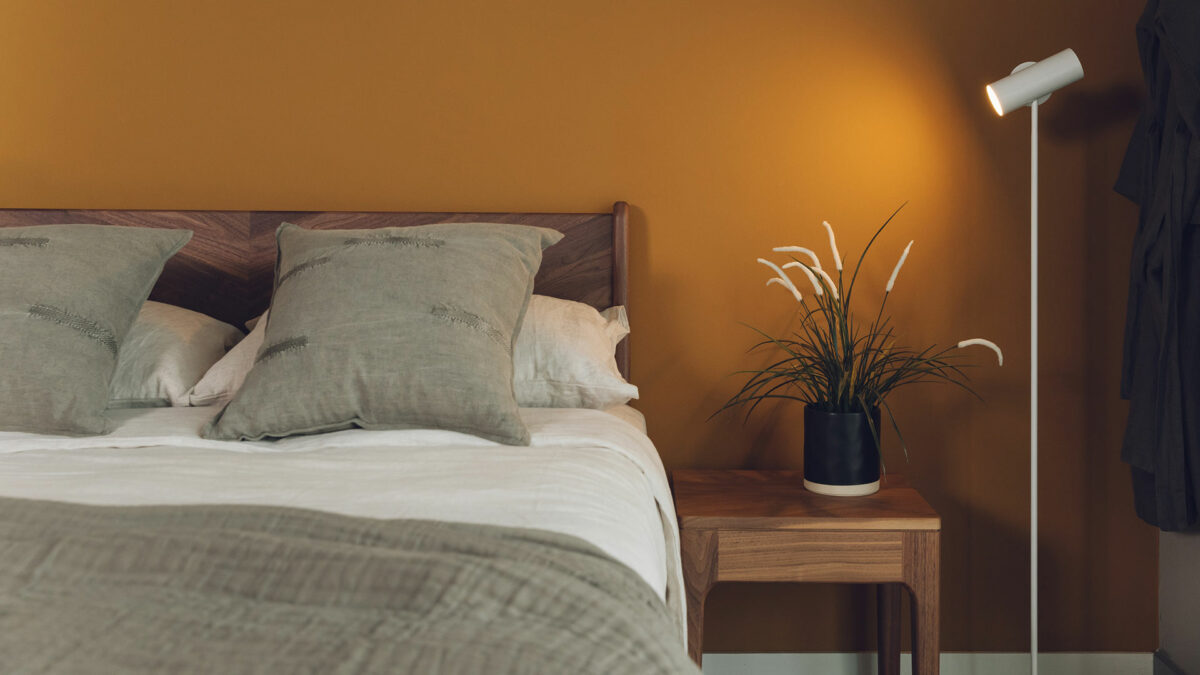light olive cushions with hoxton bed and white floor lamp