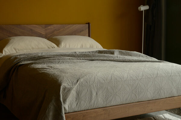 soft suede touch quilted effect bedspread in taupe shown on a kingsize bed