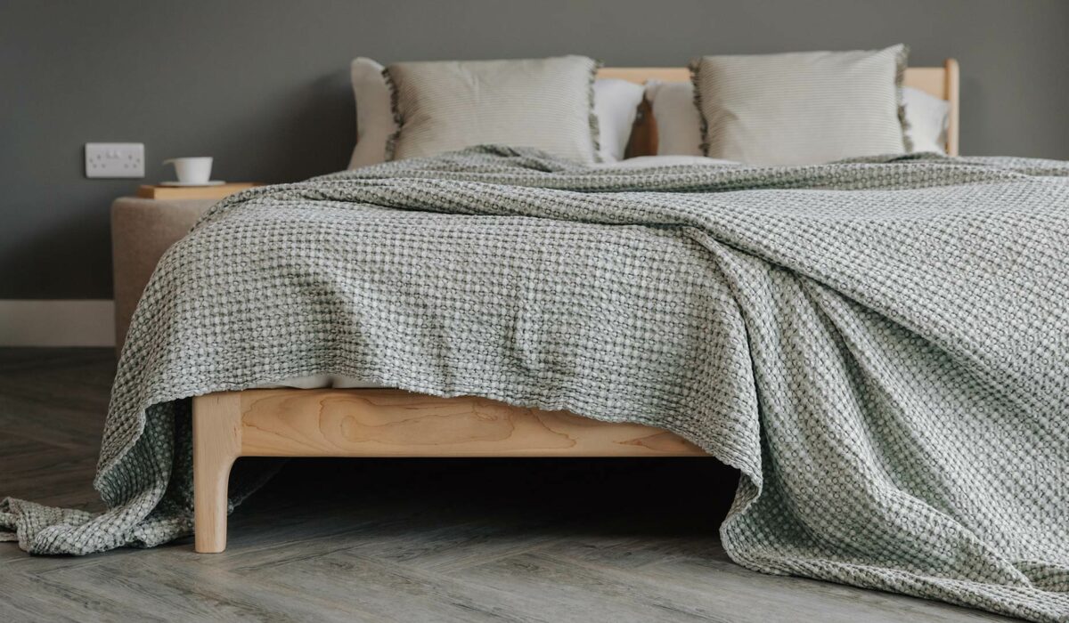 Silver-Green Bedspread displayed on a solid maple bed base