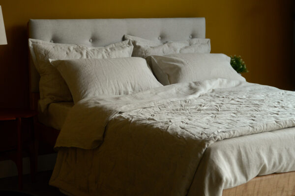 limestone linen bedding including duvet cover and pillowcases and quilted bedspread set shown on a bed