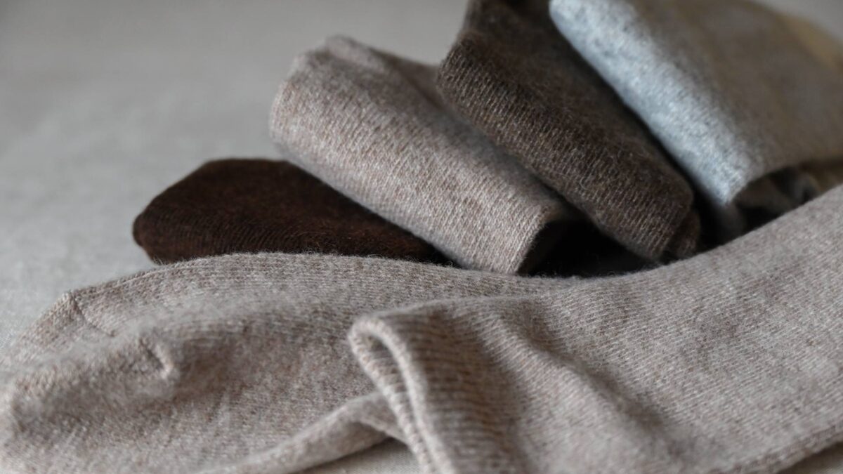 4 Pairs of folded socks in browns and grey.