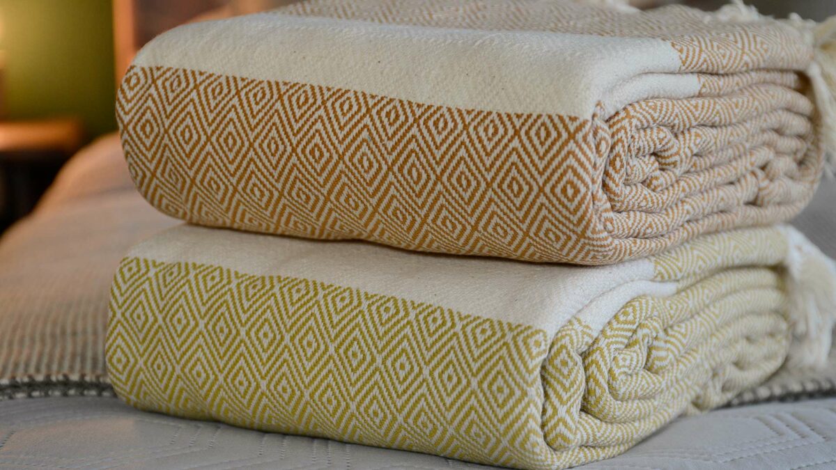 stack of woven cotton blankets with a diamond pattern