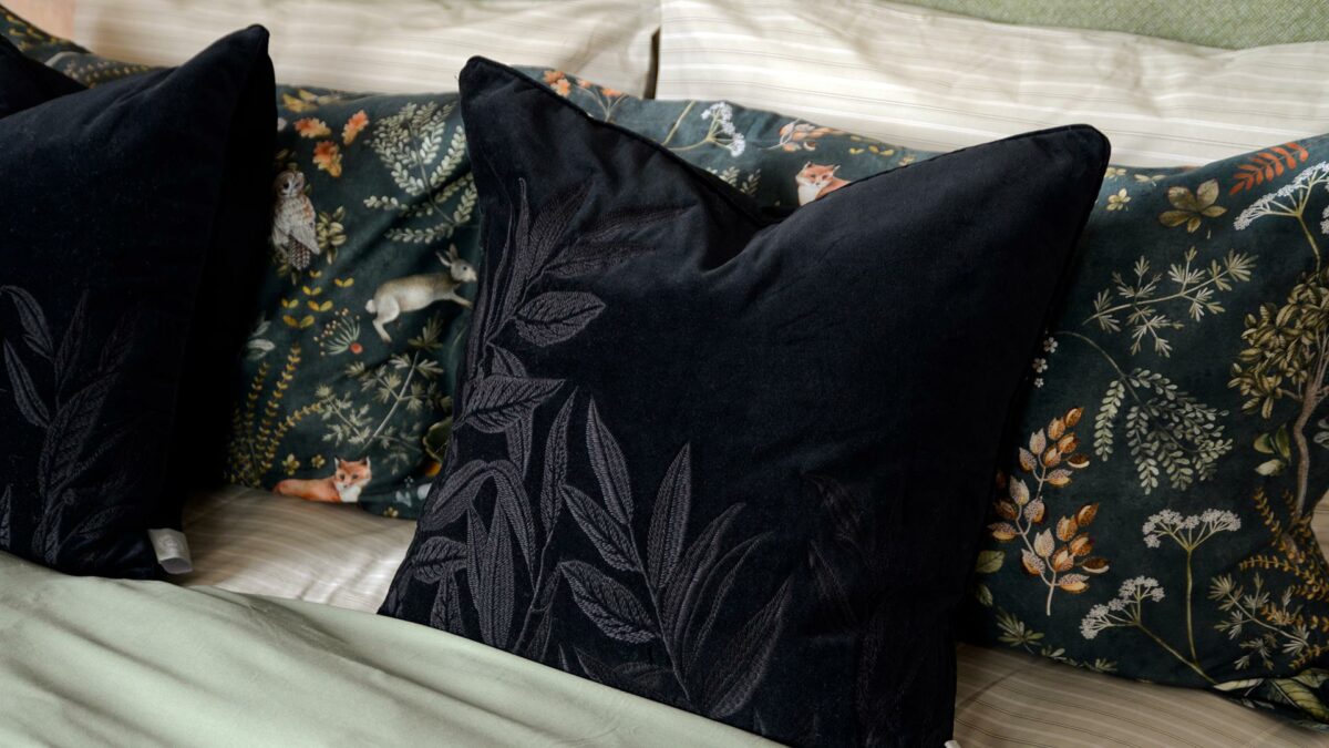 black velvet cushion with black embroidered leaves design