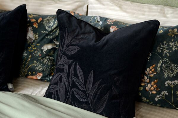 black velvet cushion with black embroidered leaves design