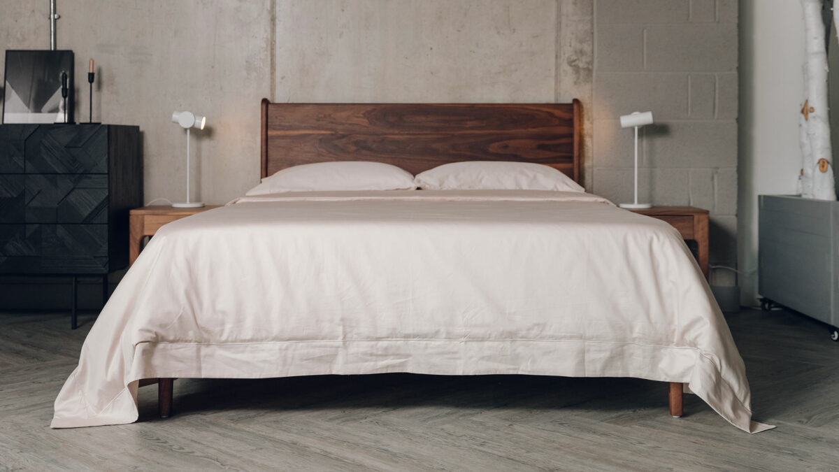 luxury sateen bedding in a shell colour shown on a kingsize walnut Camden bed