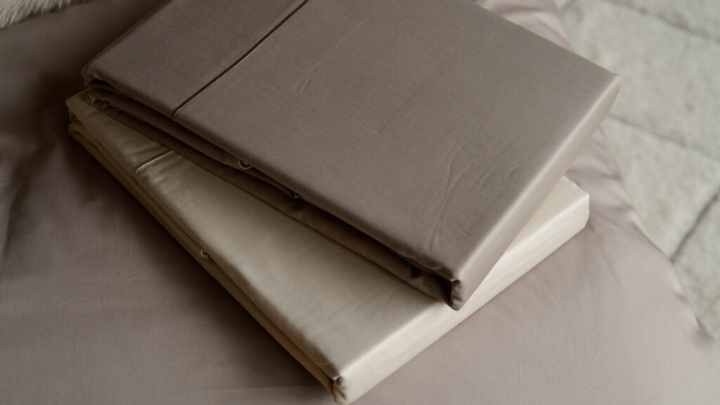 soft sheen Egyptian cotton bedding in shell and mink colours shown together in a stack