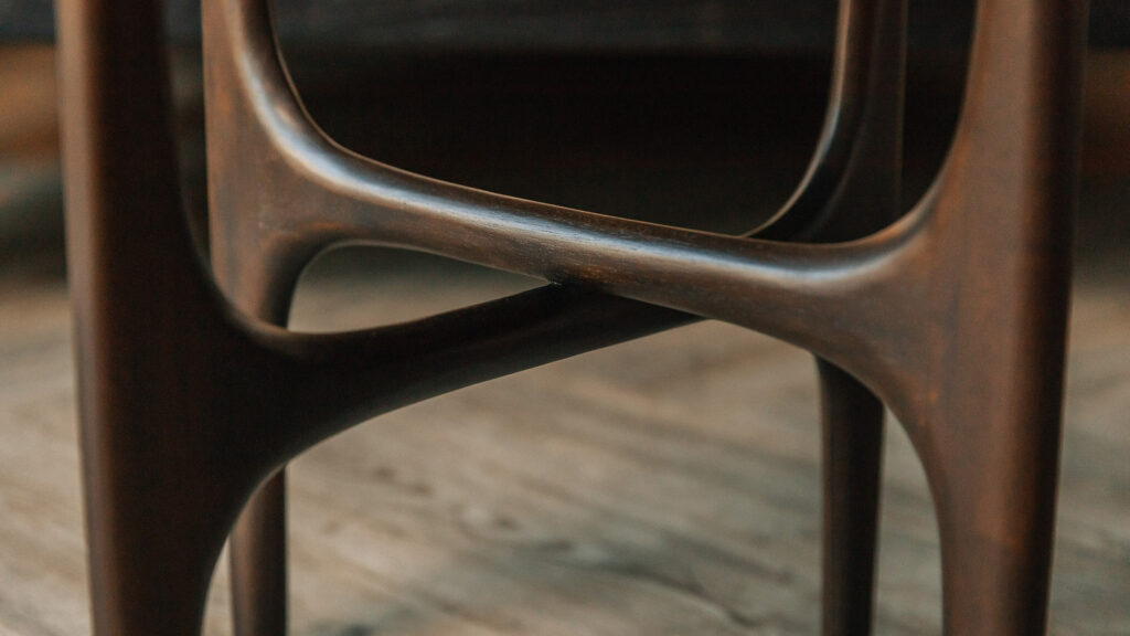 sculptural mid century style dark mahogany side table, a detail view of the carved legs