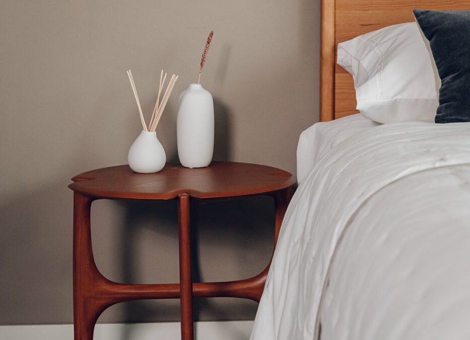 rich red mahogany side table by Ethnicraft used as a bedside table