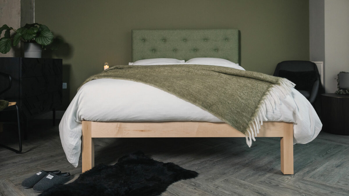 Skye bed with upholstered headboard in olive green and a maple wood base