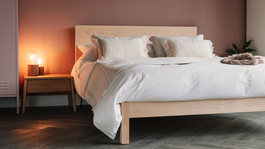 A blush pink bedroom featuring our Maple wooden Malabar bed and Air bedside table