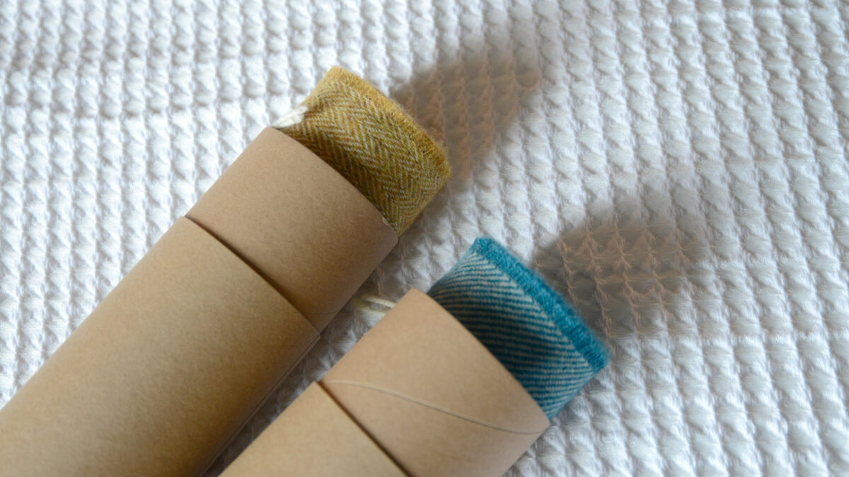 merino wool scarves in mustard and teal shown in gift tubes