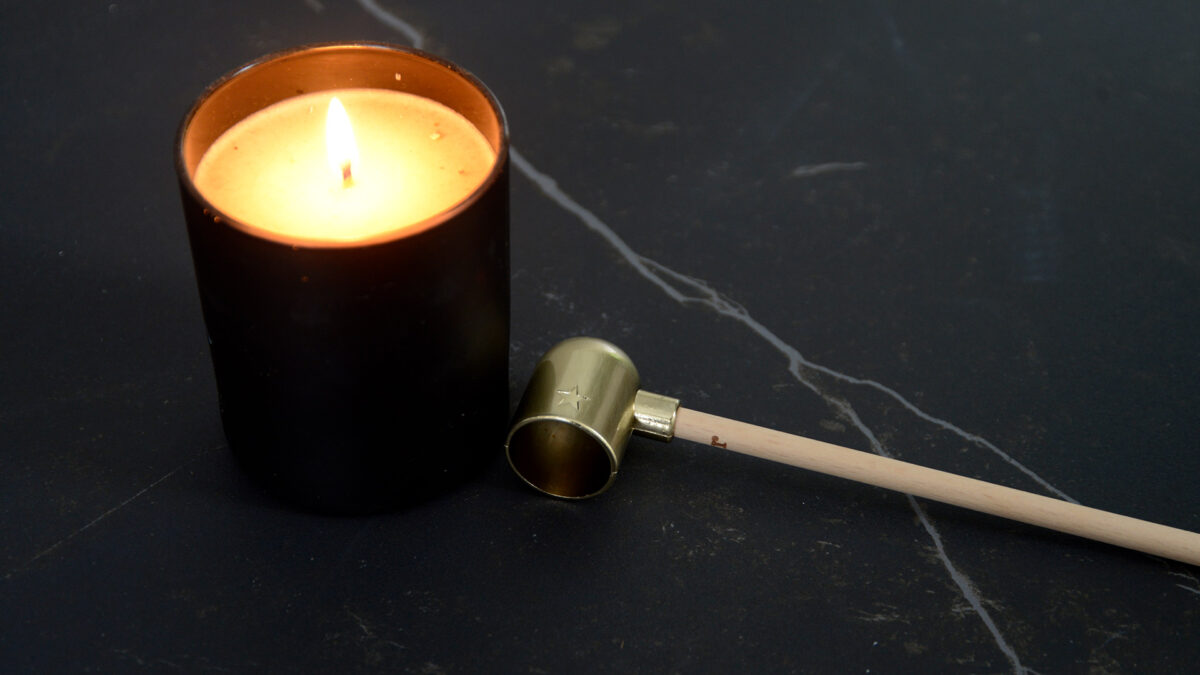 modern brass candle snuffer with a wooden handle