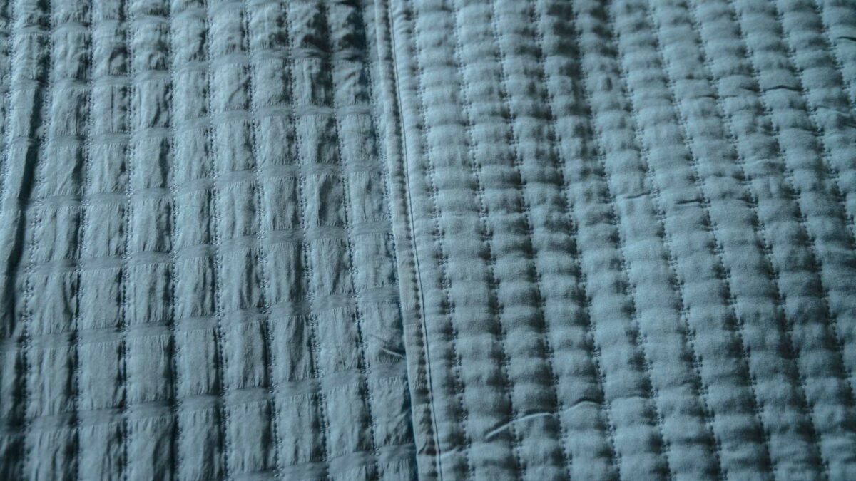 blue quilted bedspread surface pattern detail