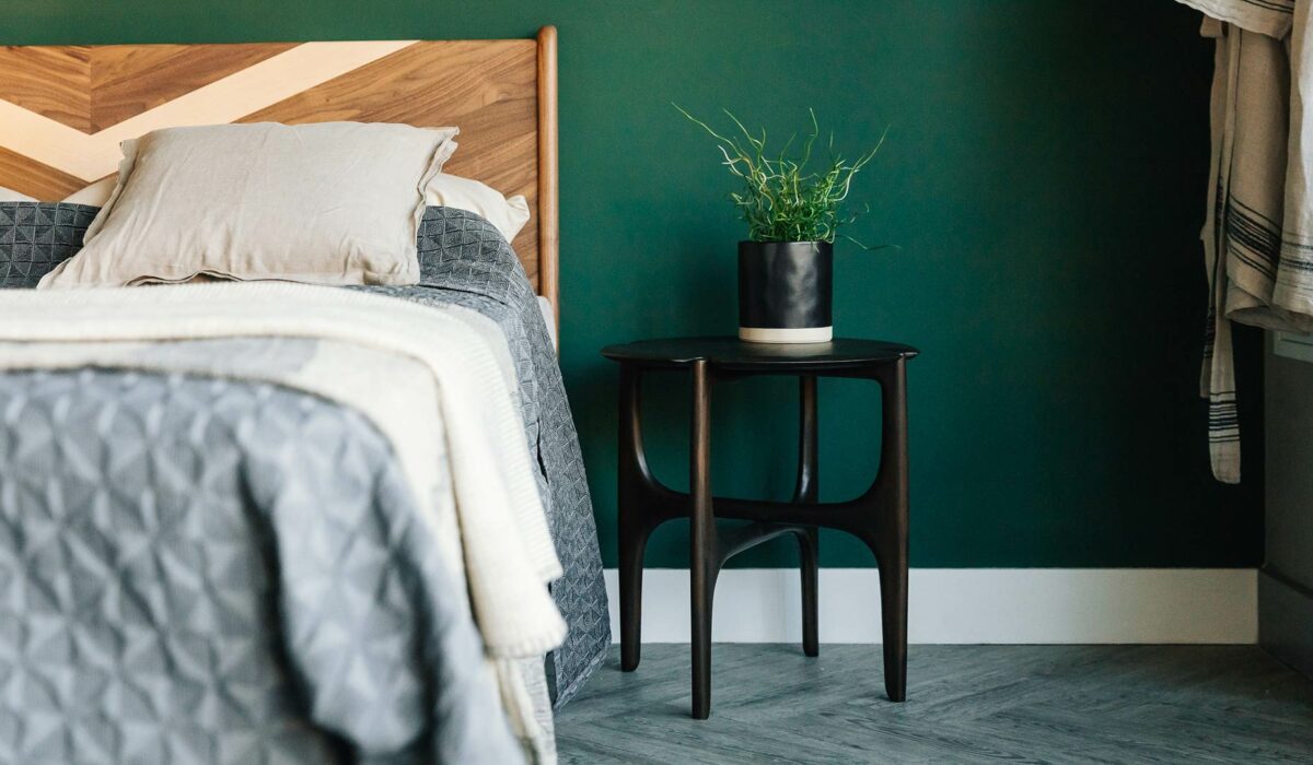 sculptural dark mahogany side table used as a bedside table