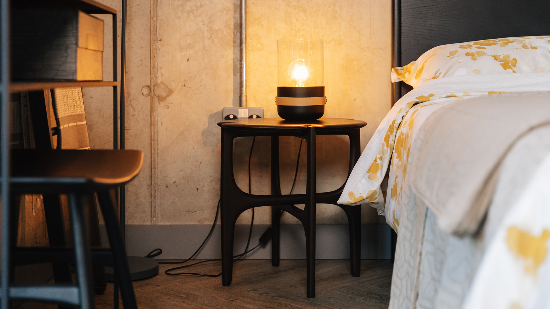 sculptural mid century style dark mahogany side table used as a bedside table