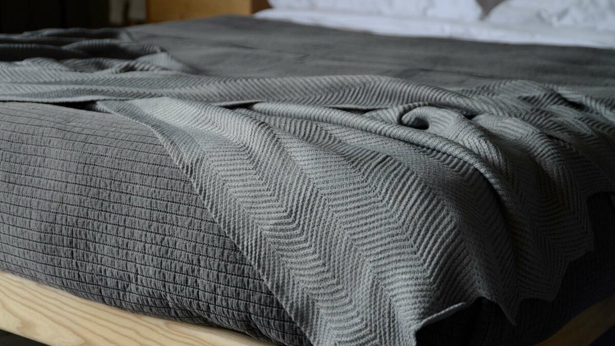 steel grey knitted throw with chevron pattern and scalloped edging