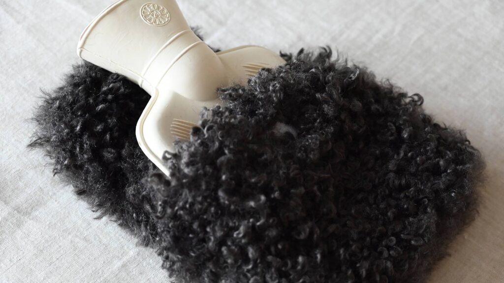 mini hot water bottle top visible in dark faux fur cover.