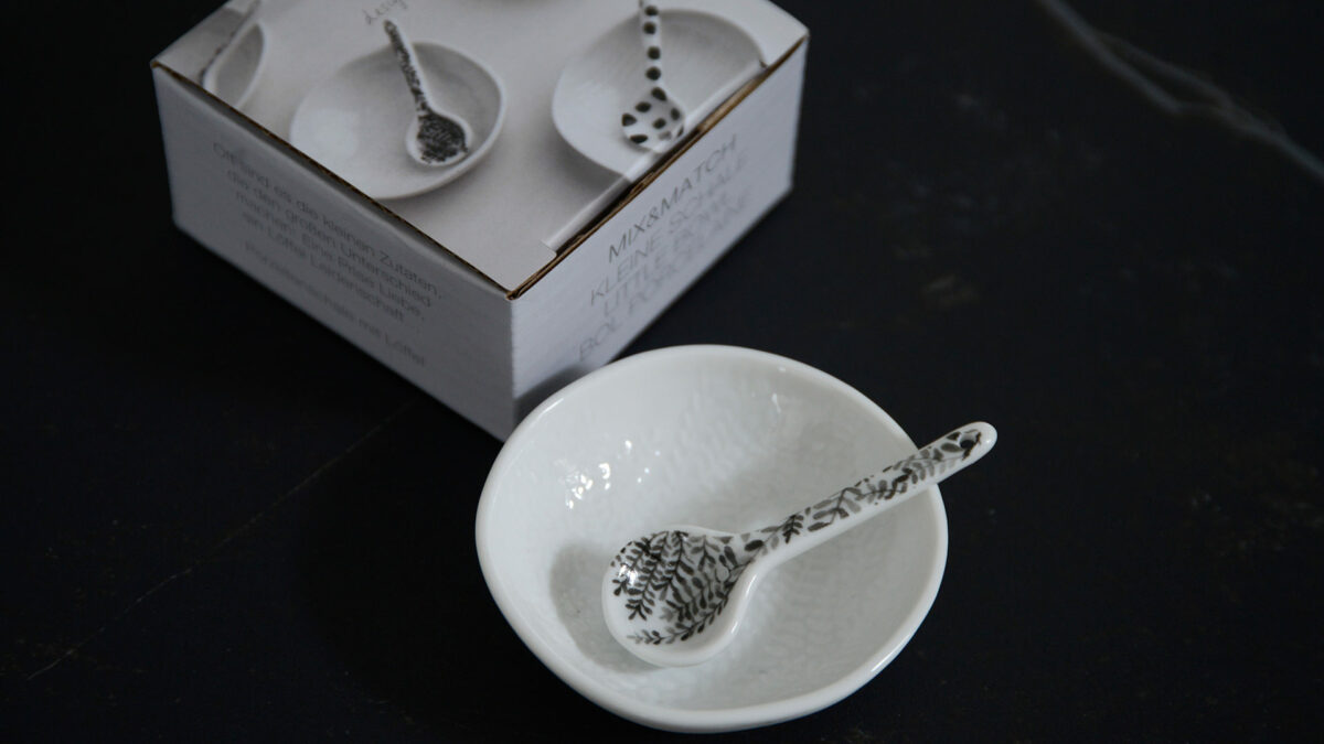 small and pretty white porcelain bowl with embossed leaf pattern to the bowl and a grey leaf pattern to the spoon