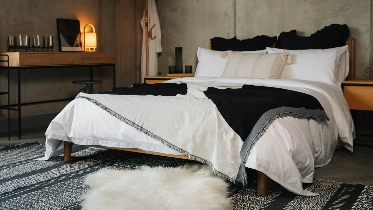 modern blanket on white and grey bedding with reversible rug