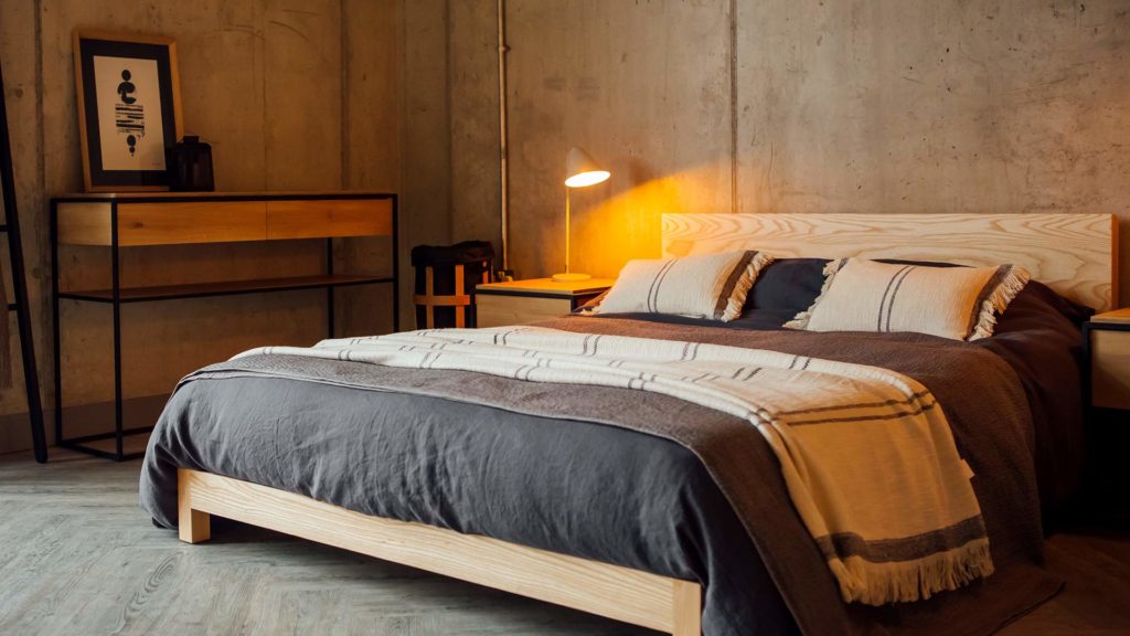 Scandi style bedroom with low pale wood Sonora bed an black framed wooden Monolit console table