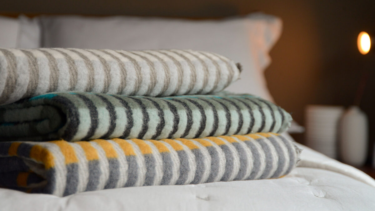 patterened fluffy throws with stripes shown folded and in a stack