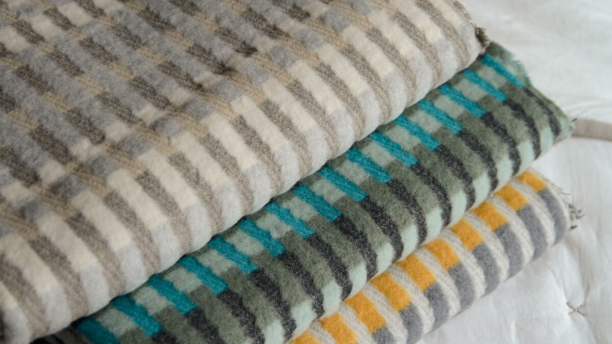 patterened fluffy throws in a choice of stripey colours shown folded together