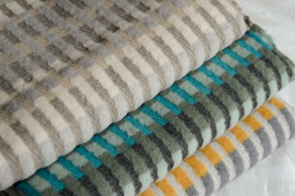 patterened fluffy throws in a choice of stripey colours shown folded together