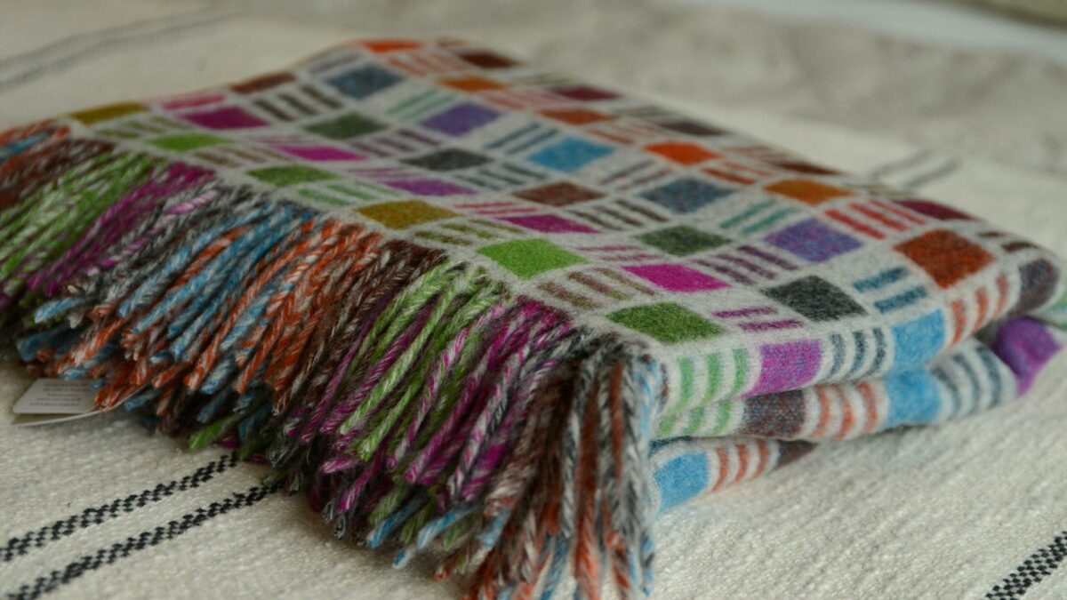 colourful patterned merino wool throw shown folded