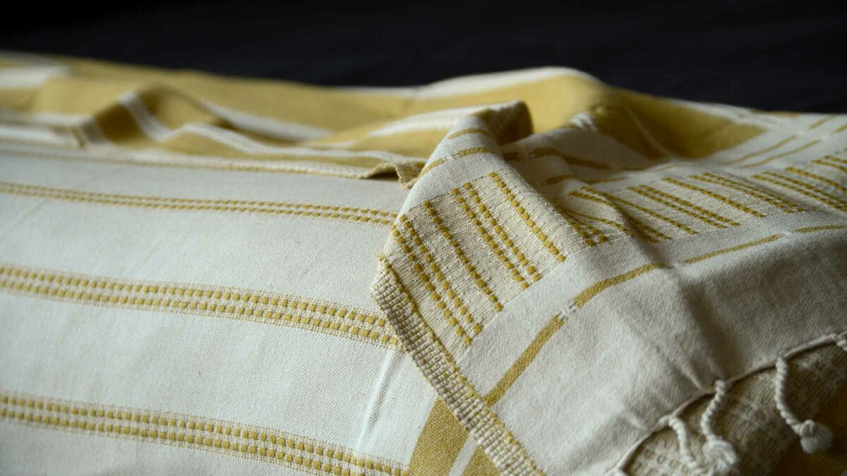 reversible mustard and ivory coloured woven cotton throw