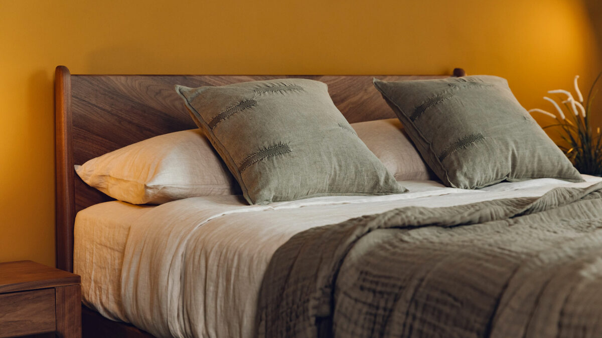 stonewashed look olive green cotton cushions shown on a kingsize bed