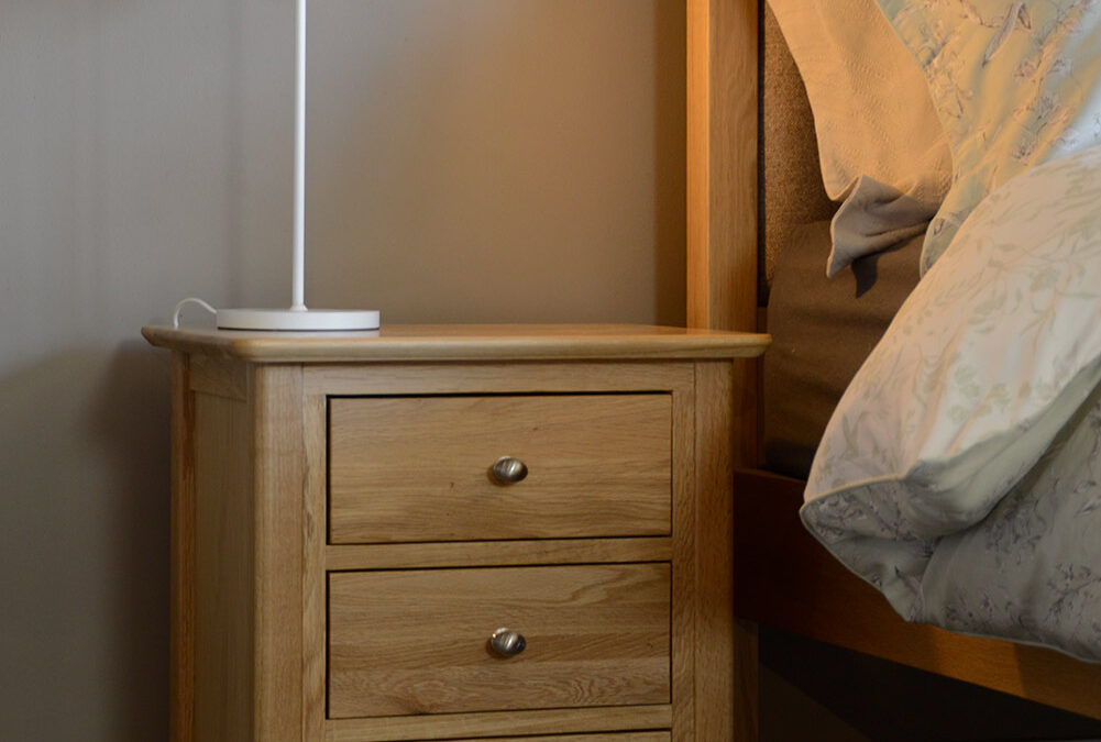 oak 3 drawer bedside unit with bed portrait